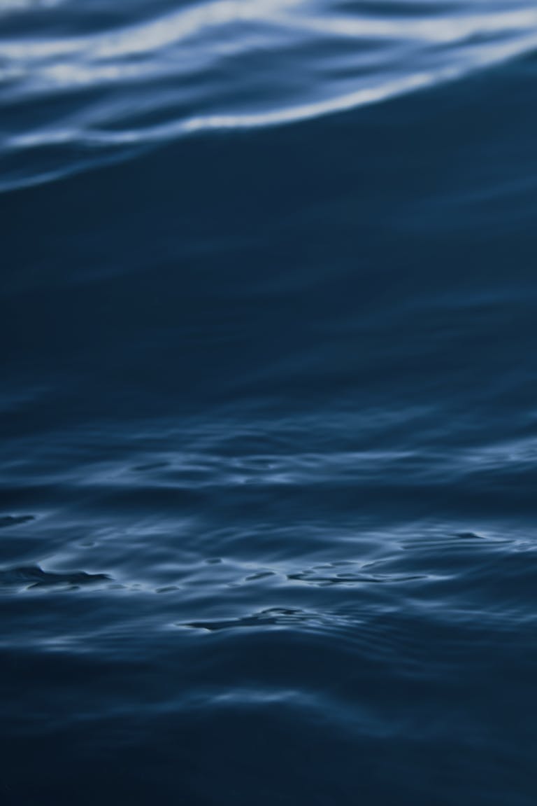 A tranquil view of dark blue ocean waves with gentle ripples and motion.